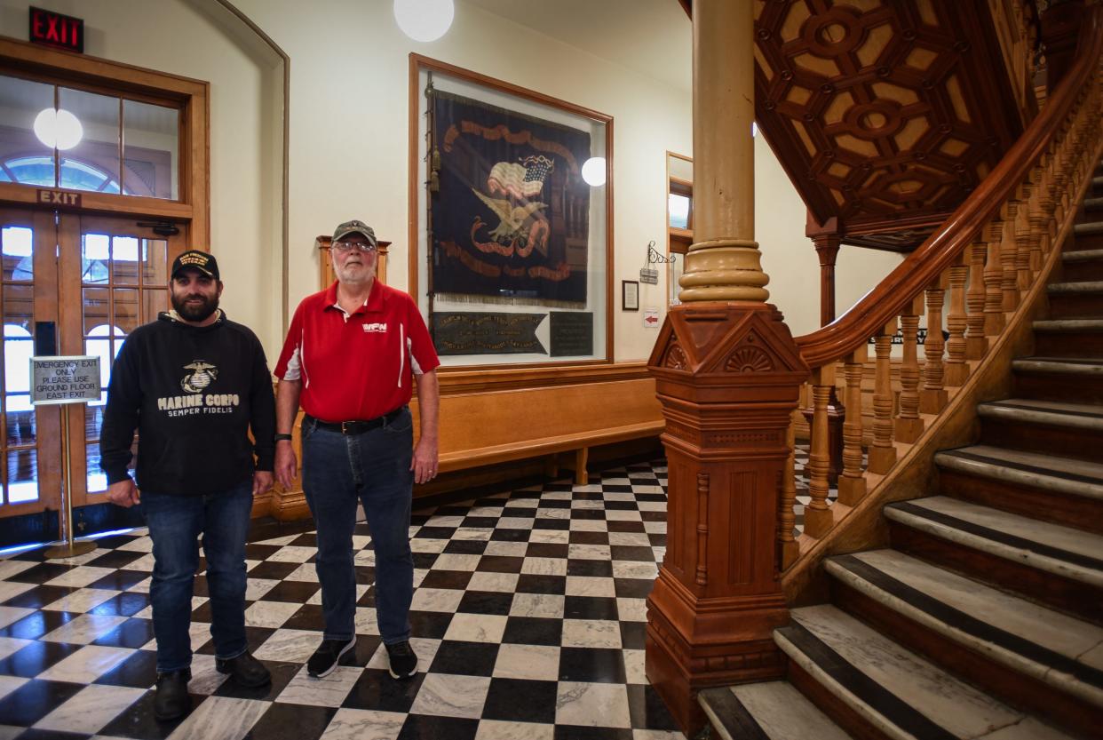 "It should be on display for the public," Eric Calley, left, of Williamston, said Wednesday, Sept. 27, 2023, while posing with fellow veteran Shane Houghton of Ionia. The two want to repair and preserve the Civil War flag behind them at the Ionia County Courthouse.