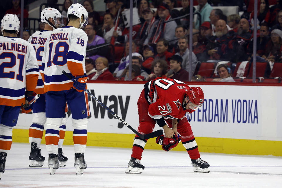 Carolina Hurricanes' Sebastian Aho (20) skates off the ice past New York Islanders' Pierre Engvall (18) and Brock Nelson (29) after being hit by the puck during the second period of Game 5 of an NHL hockey Stanley Cup first-round playoff series in Raleigh, N.C., Tuesday, April 25, 2023. (AP Photo/Karl B DeBlaker)