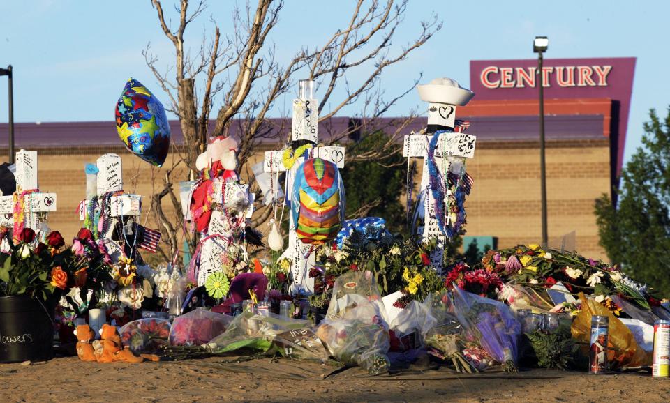 Crosses, flowers and other mementos of the victims of the Aurora, Colo., movie theater shooting are shown at sunrise a week after the tragedy. (AP/Ted S. Warren)