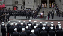 The casket of U.S. Marine Corps Staff Sergeant and FDNY Firefighter Christopher Slutman, center, arrives for his funeral service at St. Thomas Episcopal Church, Friday April 26, 2019, in New York. The father of three died April 8 near Bagram Airfield U.S military base in Afghanistan. (AP Photo/Bebeto Matthews)