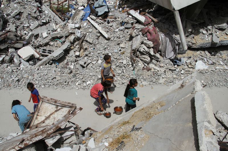 FILE PHOTO: Children walk after receiving food, amid the ongoing conflict between Israel and the Palestinian Islamist group Hamas, in Jabalia