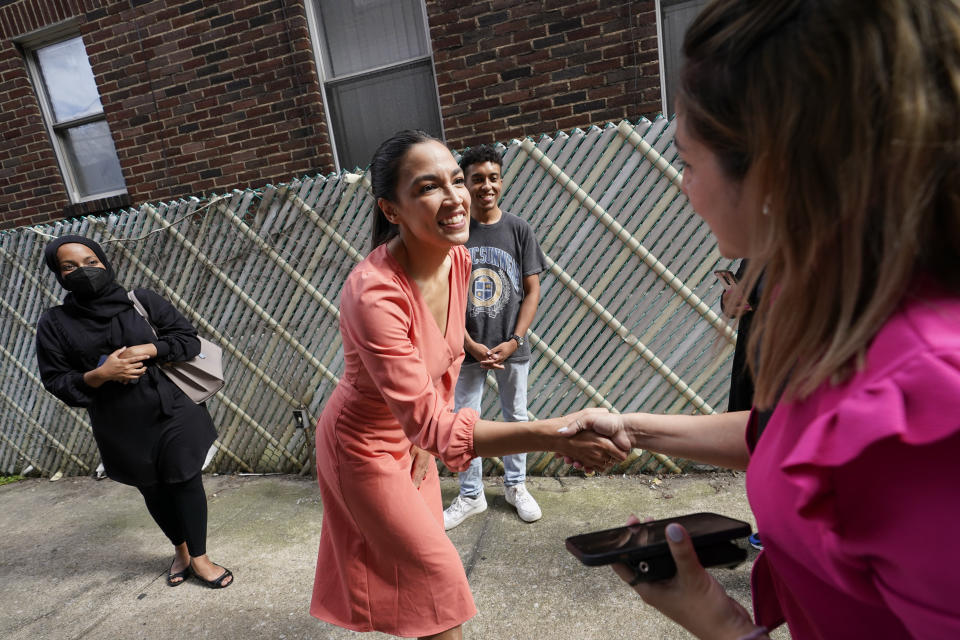 Rep. Alexandria Ocasio-Cortez, D-N.Y., center, greets residents of the Jackson Heights neighborhood of the Queens borough of New York, Wednesday, July 6, 2022. As she seeks a third term this year and navigates the implications of being celebrity in her own right, she's determined to avoid any suggestion that she is losing touch with her constituents. (AP Photo/Mary Altaffer)