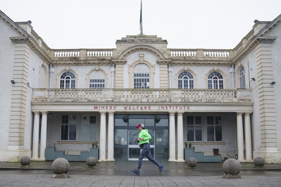 Ultra runner Helen Ryvar passes the Miners' Welfare Institute in Wrexham during running a half marathon in Wrexham, Wales, Wednesday, March 20, 2024. Helen who took up running in 2020 just before lockdown completes her daily half marathon early so as to fit in a full time job and being a single parent to 3 children. (AP Photo/Jon Super)