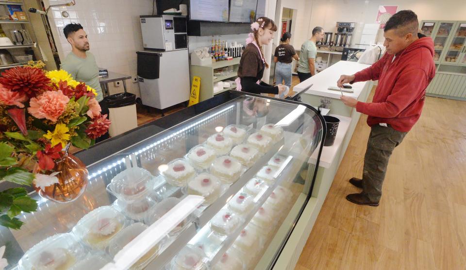 Eliza Claudio, center, helps customer Rudy Rodriguez, right, at Casa Cafe, a new Mexican bakery in Millcreek Township.