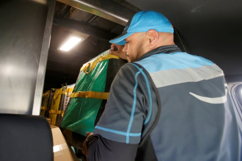 Joseph Alvarado adjust a tote that holds packages as he makes deliveries for Amazon during the outbreak of the coronavirus disease