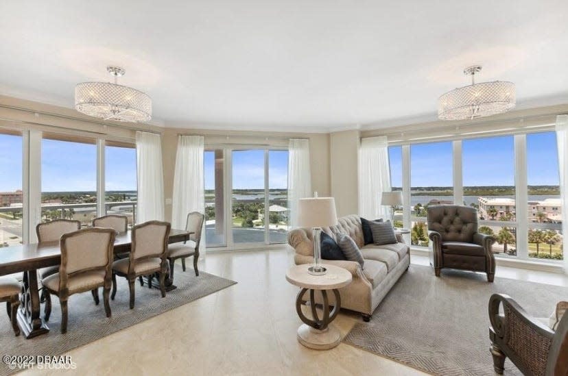 Surrounded by walls of windows that offer amazing Intracoastal Waterway views, the living room features a flat-screen TV above the fireplace and a unique crystal “fandelier."