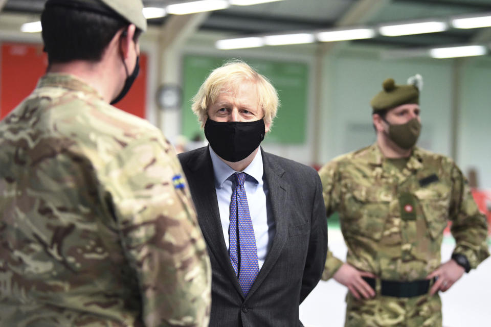 Britain's Prime Minister Boris Johnson meets with troops setting up a vaccination centre in the Castlemilk district of Glasgow, on his one day visit to Scotland, Thursday, Jan. 28, 2021. Johnson is facing accusations that he is not abiding by lockdown rules as he makes a trip to Scotland on Thursday to laud the rapid rollout of coronavirus vaccines across the United Kingdom. (Jeff Mitchell/Pool Photo via AP)