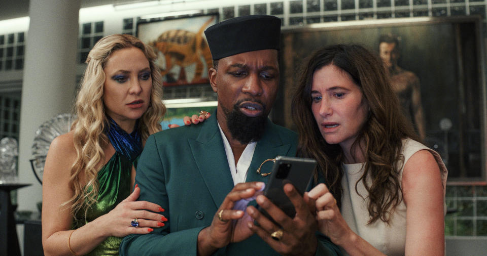 This image released by Netflix shows Kate Hudson, left, Leslie Odom Jr., center, and Kathryn Hahn in a scene from "Glass Onion: A Knives Out Mystery." (Netflix via AP)
