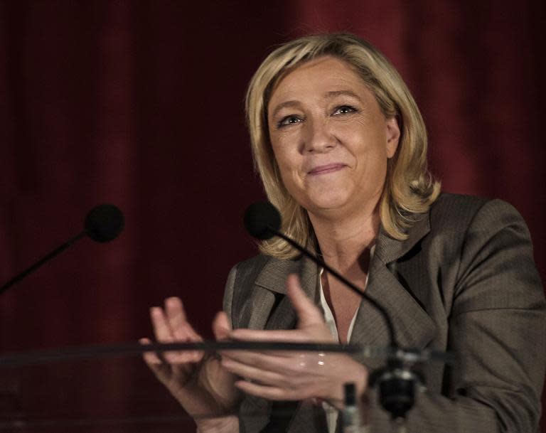 The head of France's far-right National Front party Marine Le Pen applauds during a meeting in Henin Beaumont, on March 25, 2015ahead of the second round of local elections