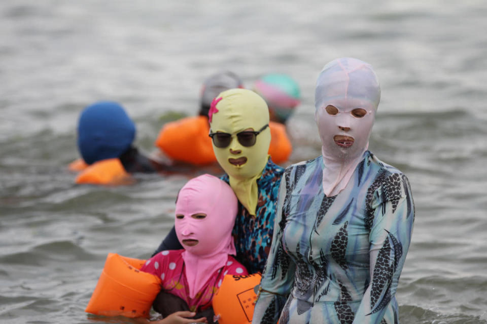 A family sport ‘facekinis’ designed from diving caps to protect the skin from sun damage and jellyfish in Qingdao, the Shandong Province of China 