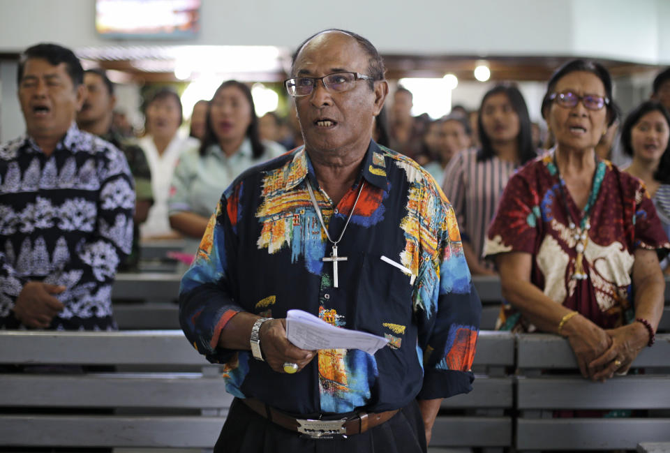 Christians sing inside a church at the earthquake and tsunami-hit town of Palu, Central Sulawesi, Indonesia Sunday, Oct. 7, 2018. Christians dressed in their tidiest clothes flocked to Sunday sermons in the earthquake and tsunami damaged Indonesian city of Palu, hoping for answers to the double tragedy that inflicted deep trauma on their community. (AP Photo/Aaron Favila)