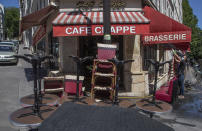 A man wears a mask to help curb the spread of the coronavirus cleans the terrace of his restaurant in Paris, Friday, May 29, 2020, as France gradually lifts its Covid-19 lockdown. France is reopening next week its restaurants, bars and cafes starting next week as the country eases most restrictions amid the coronavirus crisis. (AP Photo/Michel Euler)