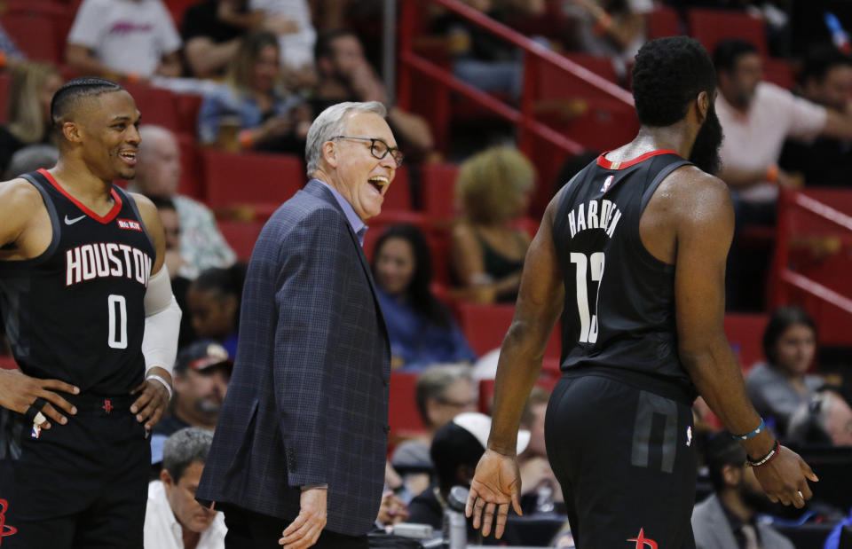 Houston Rockets coach Mike D'Antoni, center, laughs with James Harden (13) and Russell Westbrook (0) during the fourth quarter of the team's NBA preseason basketball game against the Miami Heat on Friday, Oct. 18, 2019, in Miami. The Rockets won 144-133. (AP Photo/Joe Skipper)