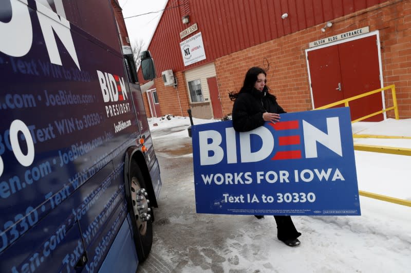 FILE PHOTO: A campaign worker for Democratic 2020 U.S. presidential candidate and former U.S. Vice President Joe Biden carries a sign after a campaign event in Mason City, Iowa