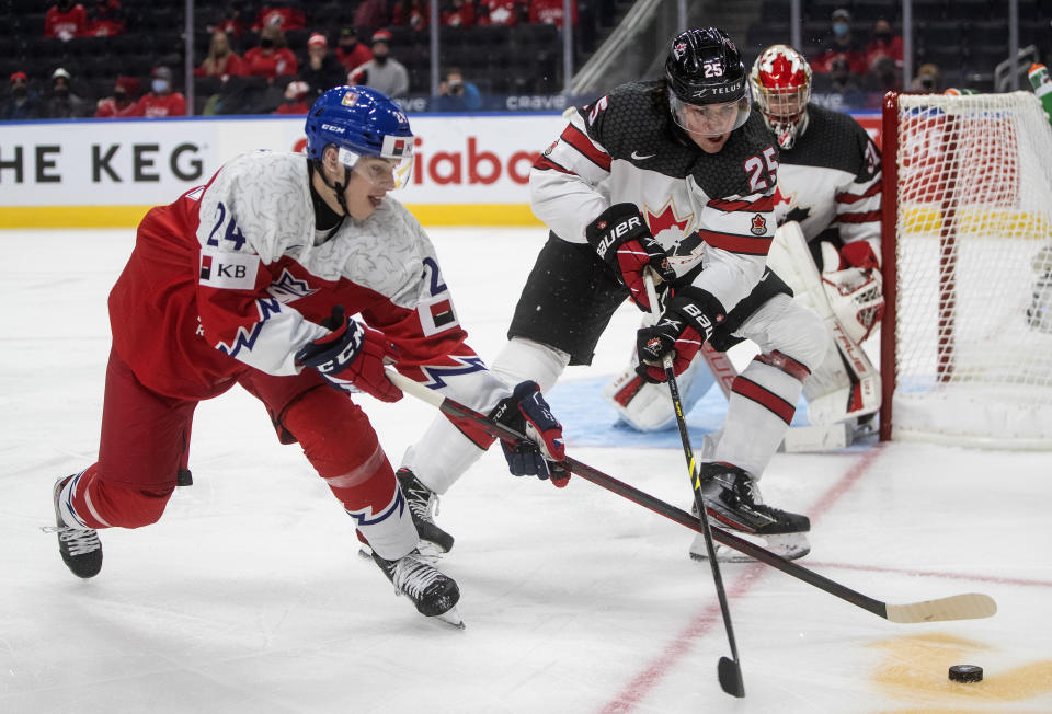 Canada's Owen Power (25) and Czech Republic's Josef Kolacek (24) battle for the puck during second-period IIHF world junior hockey championship game action in Edmonton, Alberta, Sunday, Dec. 26, 2021. (Jason Franson/The Canadian Press via AP)