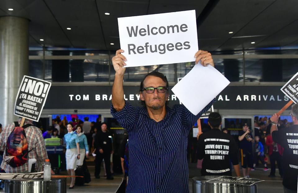 John Wider holds a sign that reads 