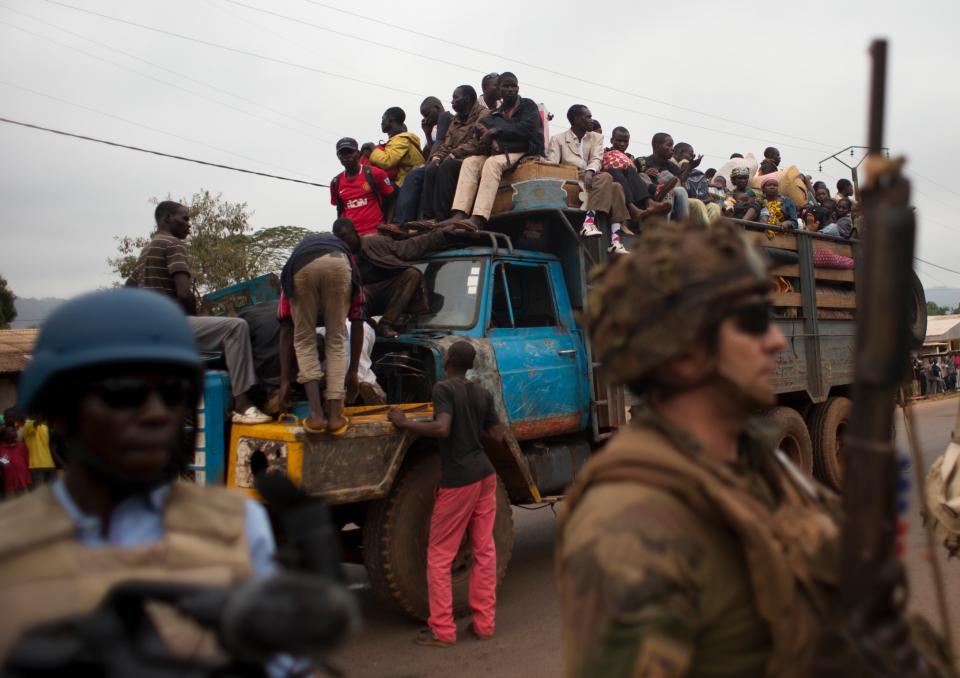 FILE - In this Friday, Dec. 27, 2013 file photo, French soldiers protect a truck of fleeing Muslims after it broke down and was surrounded by hundreds of hostile Christian residents, including several anti-balaka militiamen, in the Gobongo neighborhood of Bangui, Central African Republic. Central African Republic has long teetered on the brink of anarchy, but the new unrest unleashed by a March 2013 coup has ignited previously unseen sectarian hatred between Christians and Muslims. More than 1,000 people were killed in December alone and nearly 1 million displaced. The crisis has forced some to flee across borders to desperately poor and unstable countries like Chad and Congo. (AP Photo/Rebecca Blackwell, File)
