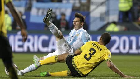 Argentina's Lionel Messi fights Jamaica's Michael Hector for the ball during their first round Copa America 2015 soccer match at Estadio Sausalito in Vina del Mar, Chile, June 20, 2015. REUTERS/David Mercado