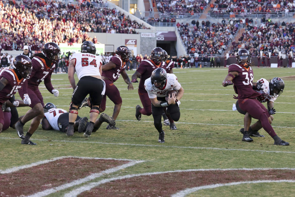 North Carolina State quarterback Brennan Armstrong, center front, scores against Virginia Tech in the first half of an NCAA college football game in Blacksburg, Va., Saturday, Nov. 18 2023. (Matt Gentry/The Roanoke Times via AP)