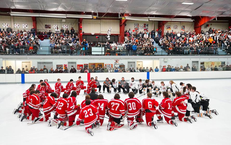 West Warwick/Exeter-West Greenwich hockey players meet at center ice for a pregame prayer after hearing the news about two teammates who were injured in a car crash.