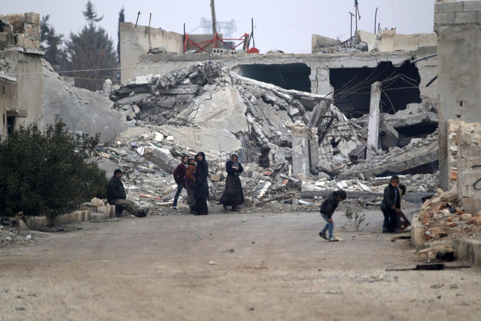 People stand near near rubble of damaged buildings in al-Rai town, northern Aleppo countryside, Syria December 25, 2016. REUTERS/Khalil Ashawi