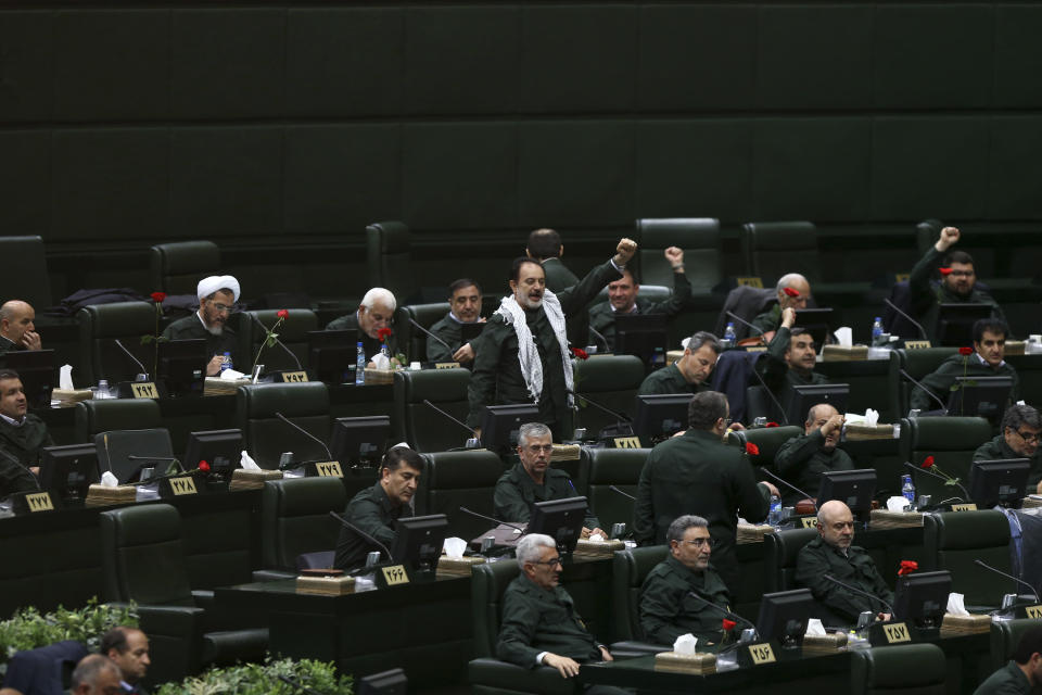 Wearing the uniform of the Iranian Revolutionary Guard, lawmakers chant slogan during an open session of parliament in Tehran, Iran, Tuesday, April 9, 2019. Chanting "Death to America," Iranian lawmakers convened an open session of parliament Tuesday following the White House's decision to designate Iran's elite paramilitary Revolutionary Guard a foreign terrorist organization. (Hamidreza Rahel/ICANA via AP)