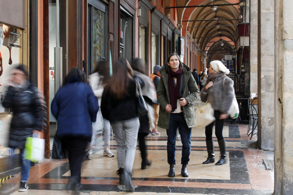 In this photo taken on Thursday, Jan. 30, 2020, Elly Schlein walks under a portico after an interview with the Associated Press, in downtown Bologna, Italy. A dual U.S.-Italian citizen who cut her political organizing teeth on two Barack Obama campaigns is emerging as the latest rising star in Italian politics. (AP Photo/Antonio Calanni)