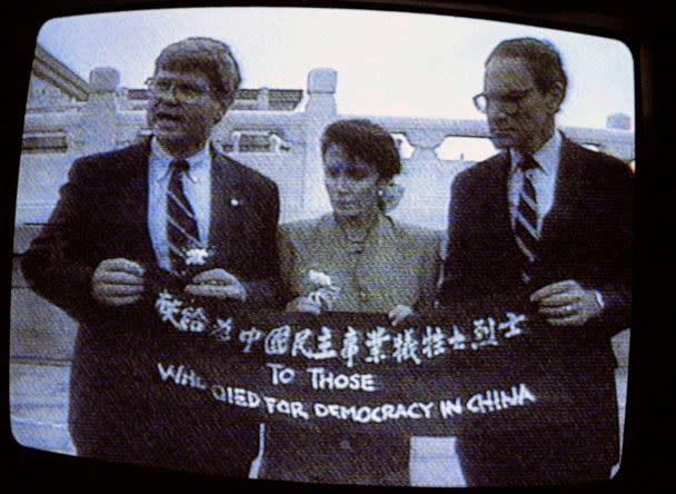 PHOTO: From left, Rep. Ben Jones, Rep. Nancy Pelosi, and Rep. John Miller, hold a banner with the words 'To those who died for democracy in China' on Tiananmen Square, Beijing, China, in an image from a TV screen, Sept 4, 1991. (AP, FILE)