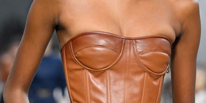 a model wearing a strapless leather bustier top on the fendi runway in a roundup of the best strapless bras for small chests 2023