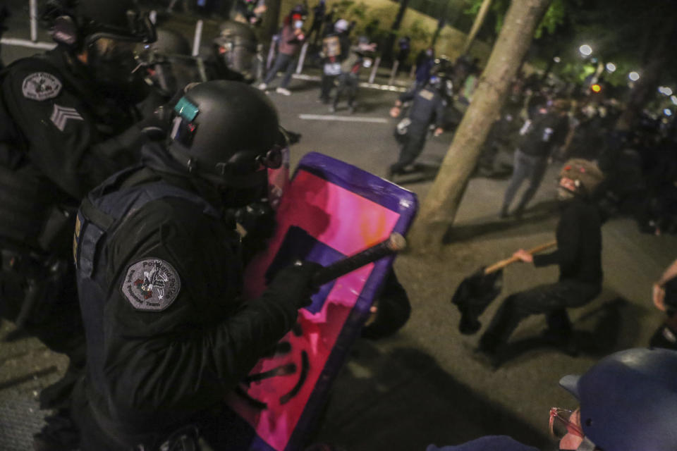 Police respond to protesters during a demonstration, Friday, July 17, 2020 in Portland, Ore. Militarized federal agents deployed by the president to Portland, fired tear gas against protesters again overnight as the city’s mayor demanded that the agents be removed and as the state’s attorney general vowed to seek a restraining order against them. (Dave Killen/The Oregonian via AP)