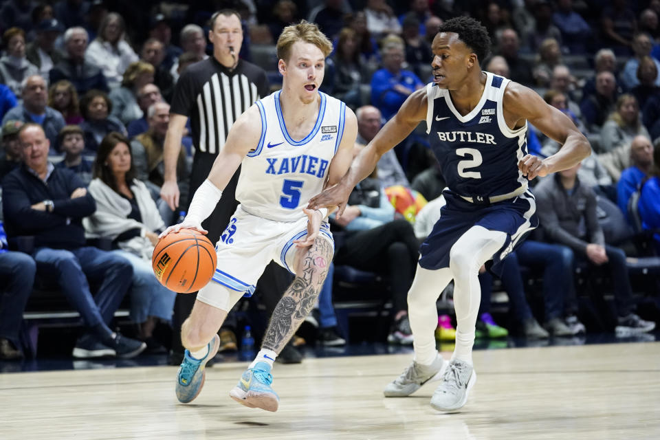 Xavier guard Adam Kunkel (5) dribbles as Butler guard Eric Hunter Jr. (2) defends during the first half of an NCAA college basketball game, Saturday, March 4, 2023, in Cincinnati. (AP Photo/Joshua A. Bickel)