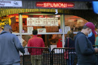 People place orders at L&B Spumoni Gardens, Sunday, Oct. 4, 2020, in the Bensonhurst/Gravesend section of the Brooklyn borough of New York. The popular neighborhood pizzeria that is also famous for its Italian ices may be forced to close down its outdoor dining area after New York's mayor said Sunday that he has asked the state for permission to close schools and reinstate restrictions on nonessential businesses in several neighborhoods because of a resurgence of the coronavirus. (AP Photo/Kathy Willens)