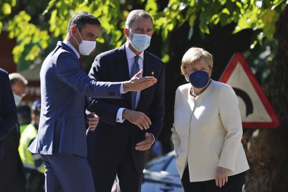 Spain's Prime Minister Pedro Sanchez, left, and Spain's King Felipe VI speak with German Chancellor Angela Merkel before she received the Spanish Charles V European award in the Yuste monastery in Cuacos de Yuste, western Spain, Thursday Oct. 14, 2021. (Manuel Angel Laya/Europa Press via AP)