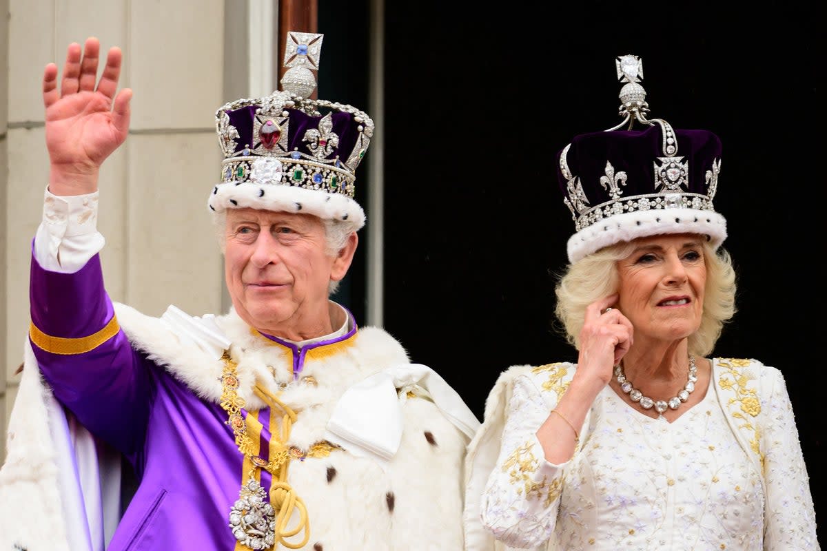 King Charles and Queen Camilla wave from the Buckingham Palace balcony following their coronations on May 6, 2023 (POOL/AFP via Getty Images)