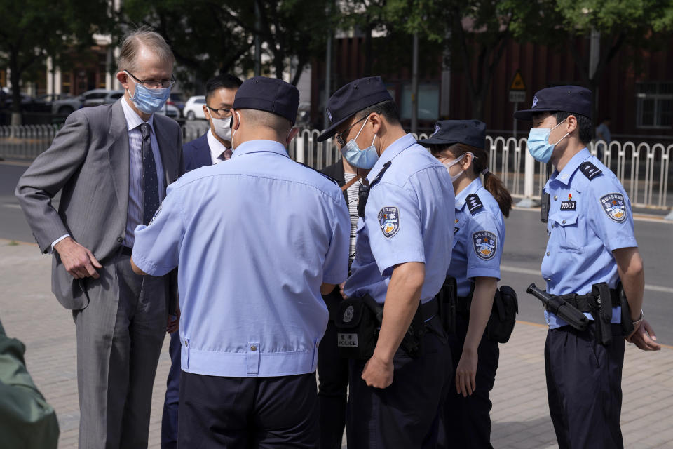 Australian ambassador to China Graham Fletcher, left, is checked by policemen outside the No. 2 Intermediate People's Court as he arrives to attend the espionage charges case for Yang Hengjun, in Beijing, Thursday, May 27, 2021. Fletcher said it was “regrettable” that the embassy was denied access Thursday as a trial was due to start for Yang, a Chinese Australian man charged with espionage. (AP Photo/Andy Wong)