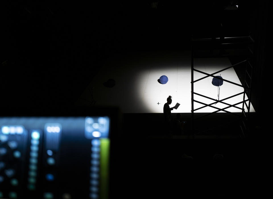 Shadow of a technician is seen on the stage of the Trafo House of Contemporary Arts while others set up the lightings in Budapest, Hungary, Sept. 19, 2022. Theaters and other cultural institutions in Hungary are reeling from exponentially growing energy prices, and some plan to close for the winter to avoid the skyrocketing bills. The Erkel Theatre in the capital of Budapest will close in November after its utilities went up as much as tenfold, and local governments across the country have ordered theaters, cinemas and museums to shut down during the cold months. (AP Photo/Bela Szandelszky)