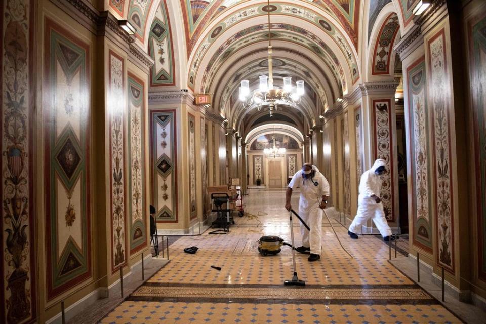 Workers clean damage near an overrun Capitol Police checkpoint a day after a pro-Trump mob broke into the US Capitol January 7, 2021, in Washington, DC.