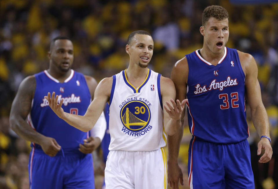 Golden State Warriors' Stephen Curry (30) argues a call next to Los Angeles Clippers' Blake Griffin (32) and Glen Davis, left, during the first half in Game 3 of an opening-round NBA basketball playoff series on Thursday, April 24, 2014, in Oakland, Calif. (AP Photo/Marcio Jose Sanchez)