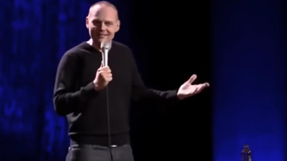 Bill Burr shrugging on stage during his act.