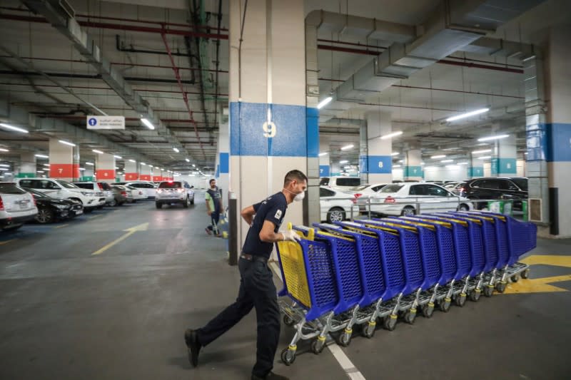 A worker wearing a face mask, amid fear of coronavirus disease (COVID-19) outbreak, pushes shopping carts at corporate Union shopping center in Dubai