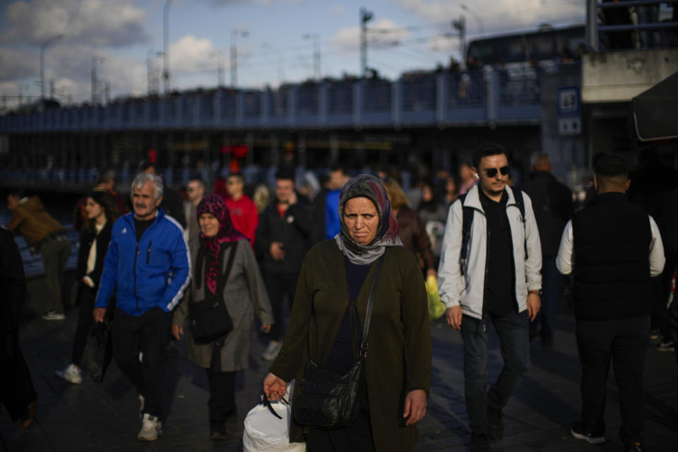 Pedestrians walk next to Galata bridge in Istanbul, Turkey, Friday, Oct. 28, 2022. Turkish President Recep Tayyip Erdogan on Friday laid out his vision for Turkey in the next century, promising a new constitution that would guarantee the rights and freedoms of citizens. (AP Photo/Francisco Seco)