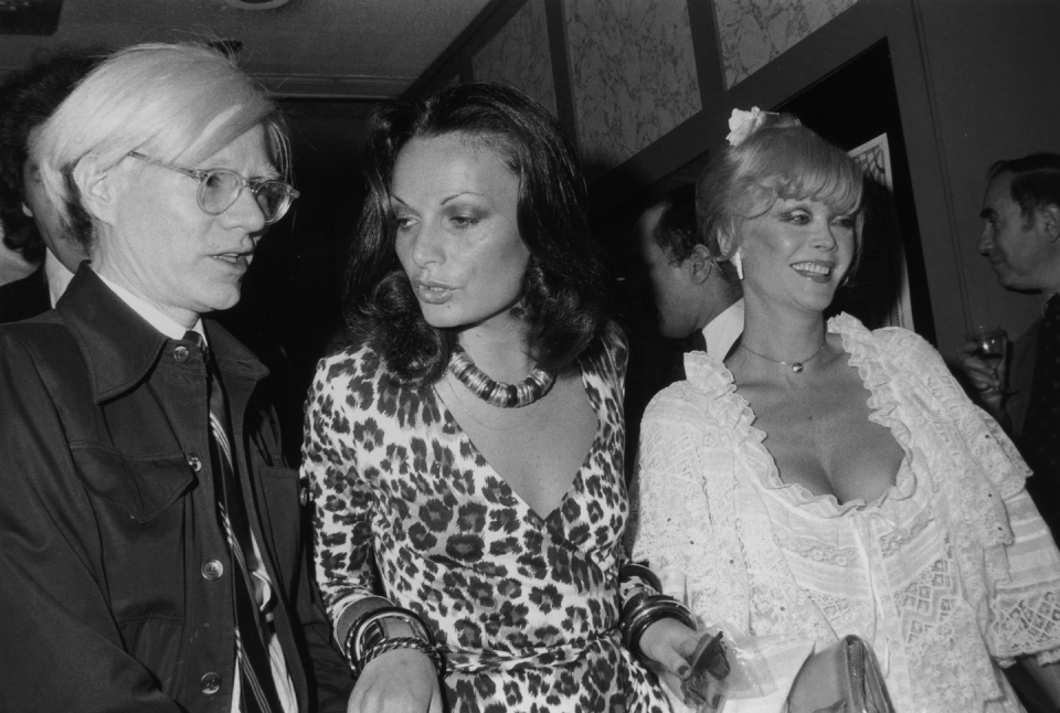 14th may 1974 left to right artist andy warhol 1928 1987, fashion designer diane von furstenberg, and actor monique van vooren, star of warhol's 'flesh for frankenstein,' at the film's premiere at the trans lux east theater in new york city von furstenberg is wearing one of her own designs, a leopard print wrap dress photo by tim boxerhulton archivegetty images