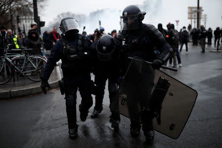 A French police officer in riot gear, injured during clashes with protesters, is given help during a demonstration by the "yellow vests" movement at Place de la Bastille in Paris, France January 26, 2019. REUTERS/Benoit Tessier