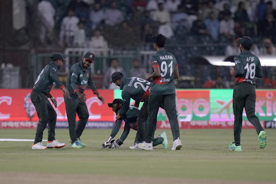 Bangladesh's Mushfiqur Rahim, center on ground, is congratulated by with teammates after he taking the catch of Afghanistan's Ibrahim Zadran during the Asia Cup cricket match between Bangladesh and Afghanistan in Lahore, Pakistan, Sunday, Sept. 3, 2023. (AP Photo/K.M. Chaudary)