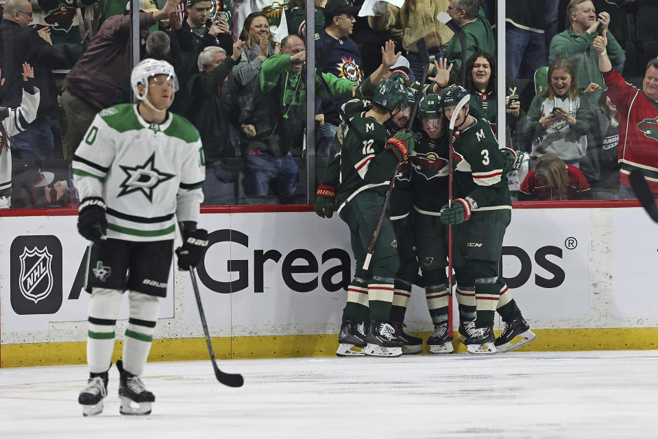 Minnesota Wild left wing Marcus Johansson, second from left at rear, is surrounded by teammates in celebration of his goal against the Dallas Stars during the second period of Game 3 of an NHL hockey Stanley Cup first-round playoff series Friday, April 21, 2023, in St. Paul, Minn. (AP Photo/Stacy Bengs)