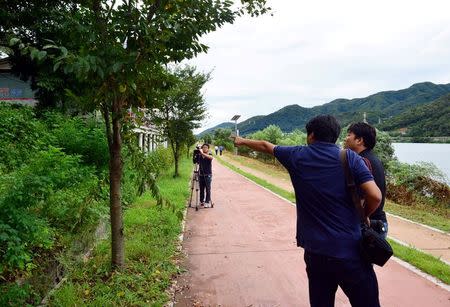 A photographer points at where the body of Lotte Group Vice Chairman Lee In-won was found in Yangpyeong, South Korea, August 26, 2016. Choi Hyun-kyu/News1 via REUTERS