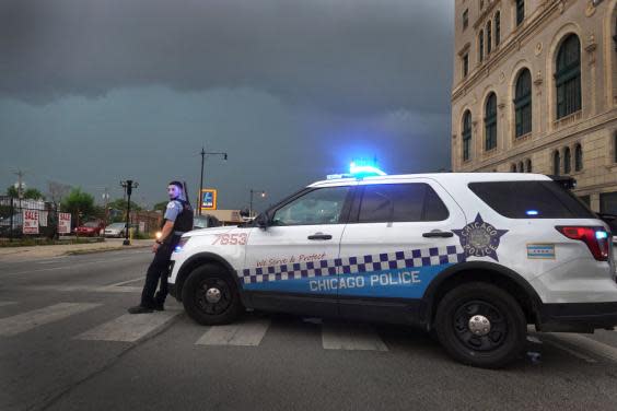 A police officer stands guard following unrest on the city’s westside moments before a derecho storm hits the area on August 10, 2020 in Chicago, Illinois. The storm, with winds gusts close to 100 miles per hour, downed trees and power lines as it moved through the city and suburbs. (Photo by Scott Olson/Getty Images) (Getty Images)