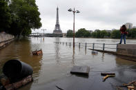 <p>A woman, at right, takes photos of the flooded banks of the Seine river in Paris, June 4, 2016. An international team of scientists has found that man-made climate change nearly doubled the likelihood of last month’s devastating French flooding. In a quick but not peer reviewed analysis, the World Weather Attribution team of climate scientists used past rainfall data and computer simulations to look for global warming’s fingerprints in the heavy downpours in France and Germany. (AP Photo/Francois Mori) </p>