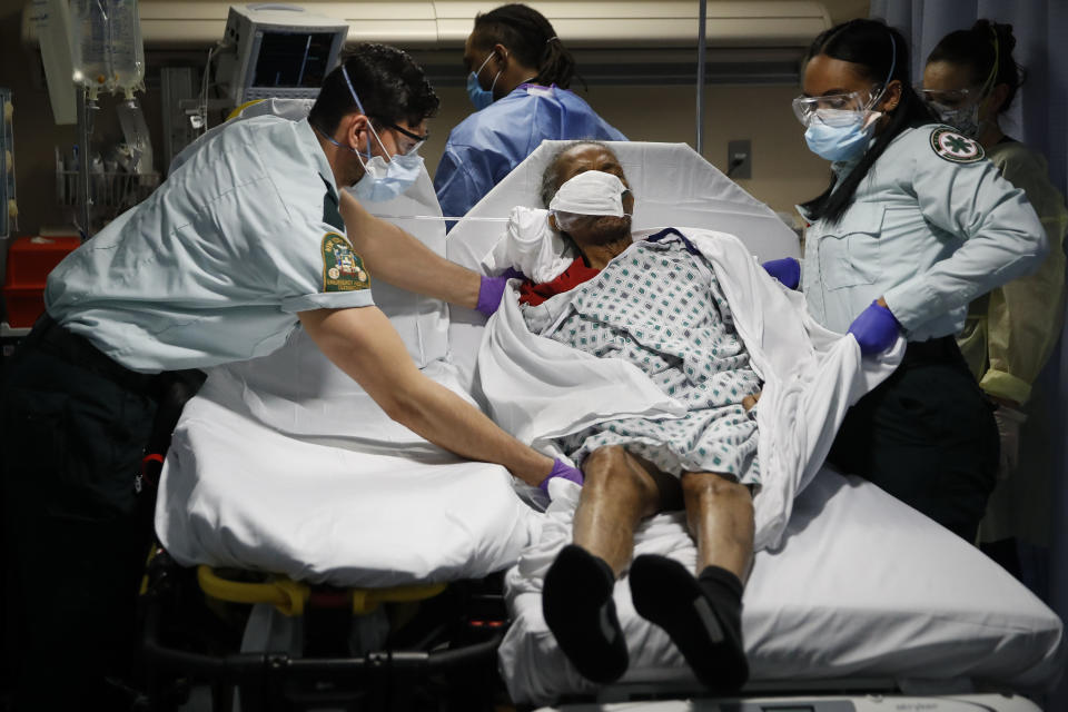 Emergency medical technicians transport a patient from a nursing home to an emergency room bed, Monday, April 20, 2020, at St. Joseph's Hospital in Yonkers, N.Y. (AP Photo/John Minchillo)