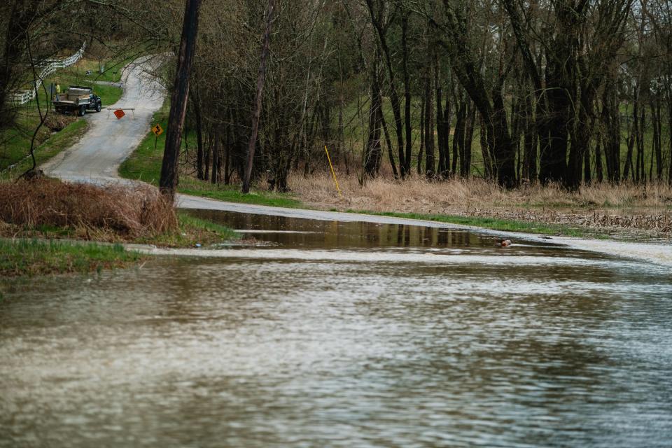 A worker makes adjustments to a sign on Sattler Bottom Rd, Tuesday, April 2, just outside of Zoarville.